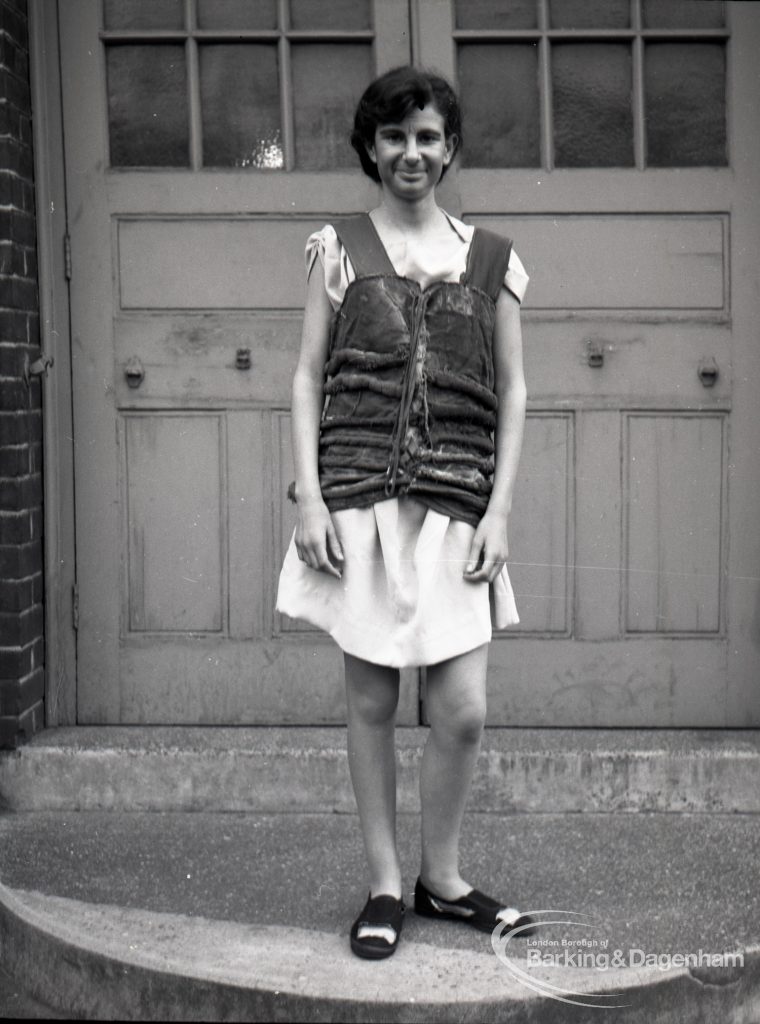 Dagenham Secondary school play, with children performing Androcles and the Lion, showing member of cast on steps at school entrance, 1965