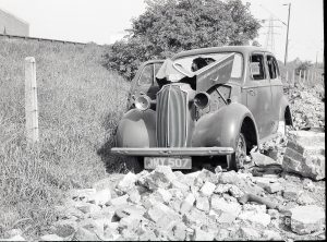 Riverside Sewage Works Reconstruction V, showing derelict car abandoned by railway fence, 1965