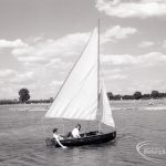Boating at Mayesbrook Park, Dagenham, showing yacht sailing, with girl trailing hand in water, 1965