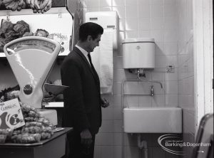 Health education, showing Inspector by washbasin for hand washing next to greengrocery section at Wallis Supermarket, Rush Green, 1965