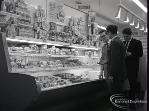 Health education, showing Inspector with Manager looking at refrigerated food shelves at Wallis Supermarket, Rush Green, 1965