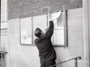 Civic Centre, Dagenham, showing member of staff putting an official notice on board, 1965