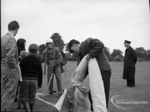 Dagenham Town Show 1965, showing a free fall parachute display by members of the Green Jackets Brigade, with parachutists, one folding parachute, and spectators, 1965