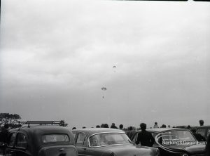 Dagenham Town Show 1965, showing a free fall parachute display by members of the Green Jackets Brigade, with parachutist nearing ground, over car park, 1965