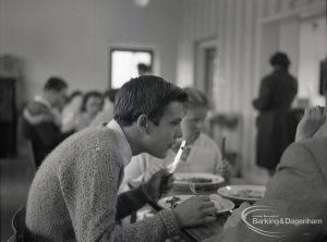 Adult Training College at Osborne Square showing a boy looking and eating at lunch time, 1965
