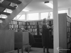 New Barking Library Lending Department, showing view underneath staircase, with bookshelves, borrower, and library catalogue, 1965