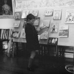 Barking Libraries exhibition at Valence House, Dagenham for National Book Week, showing child studying a book on Fairy Tales display stand, 1966