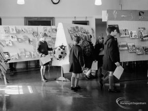 Barking Libraries exhibition at Valence House, Dagenham for National Book Week, showing group of children looking at books on display stands, 1966