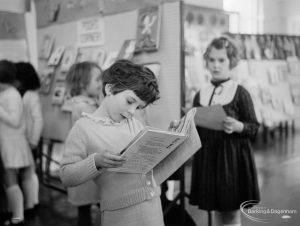 Barking Libraries exhibition at Valence House, Dagenham for National Book Week, showing a young girl reading, 1966