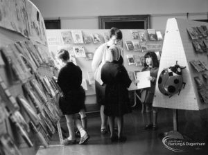 Barking Libraries exhibition at Valence House, Dagenham for National Book Week, showing member of staff and three girls in ‘Secondary’ book area, 1966