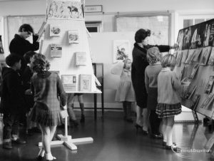 Barking Libraries exhibition at Valence House, Dagenham for National Book Week,showing children and parents looking at book display at east end of the Museum Room, 1966