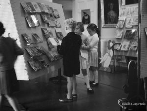 Barking Libraries exhibition at Valence House, Dagenham for National Book Week, showing children in the ‘Primary’ display area with a cardboard cut-out of Mother Goose, 1966