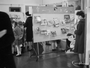 Barking Libraries exhibition at Valence House, Dagenham for National Book Week, showing children and parents looking at books on astronomy and other display stands, 1966
