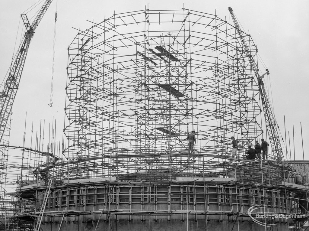 Riverside Sewage Works Reconstruction X showing a circular steel framework with cranes and three figures, 1966