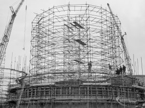 Riverside Sewage Works Reconstruction X showing a circular steel framework with cranes and three figures, 1966