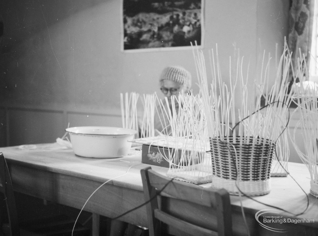 Training Centre at Eastbury House, Barking, showing half-made baskets on table, with woman sitting behind, 1966