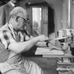 Training Centre at Eastbury House, Barking, showing men doing woodwork, with one man seated and drilling holes, and another man in background, 1966
