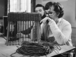 Training Centre at Eastbury House, Barking, showing woman with hand to mouth making a basket, 1966