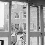 Training Centre at Eastbury House, Barking, showing view from inside Solarium showing two wheelchair users in grounds, with Eastbury House beyond, 1966