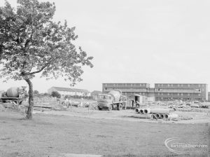 South side of Becontree Heath cleared for new development, with drain pipes and concrete mixers in front of Althorne Way flats under construction, and tree at left, 1966