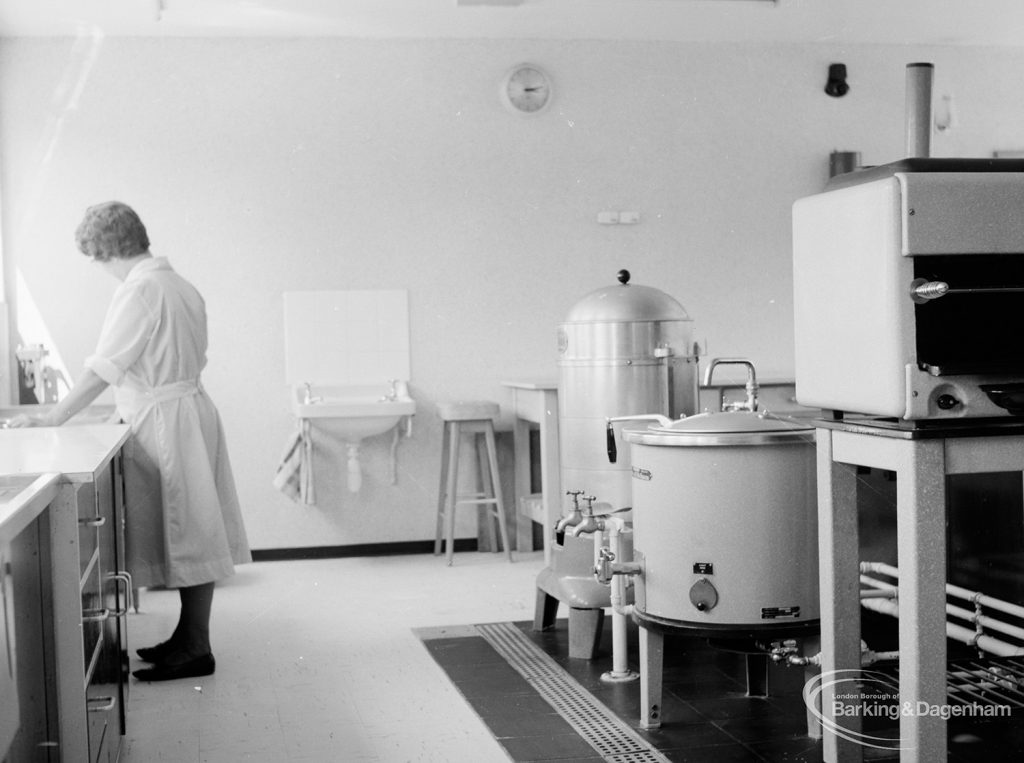 Saywood Lodge, Weston Road showing a member of the kitchen staff in the kitchen surrounded by modern appliances, 1966