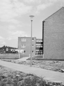 An aluminium lamp against the sky, in front of blocks of flats [possibly in Barking or Dagenham], 1966