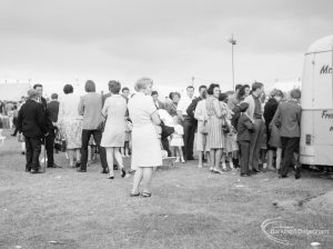 Dagenham Town Show 1966 at Central Park, showing people queuing by a van with a woman in the middle wearing white, 1966