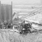 Riverside Sewage Works Reconstruction, showing Hadsphaltic digger submerged in clay, seen from grass bank above, and with crane’s rig to right, 1966