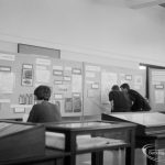 Barking Abbey 1300th anniversary exhibition at Barking Central Library, showing visitors studying wall displays on stands, 1966