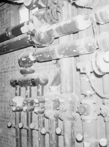 Heating, showing horizontal water pipes above seven vertical pipes at Heath Park substation, 1966