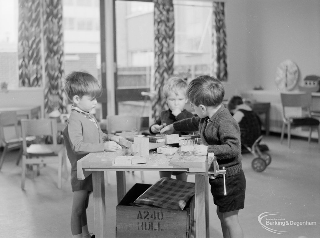 Health, showing rebuilt Ashton Road Clinic, Chadwell Heath, with three children at play at workbench in Nursery, 1966