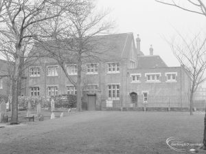 Barking Church of England School, later known as St. Margaret’s Church of England School, Back Lane, Barking, showing the main school building with Barking Abbey burial site in foreground, 1967