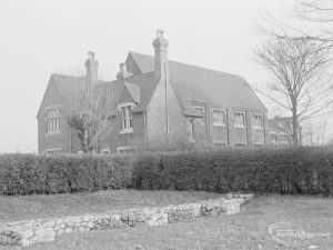 Barking Church of England School, later known as St. Margaret’s Church of England School, Back Lane, Barking, showing the western frontage, seen from Barking Abbey grounds with tree, shrubs and stones, 1967