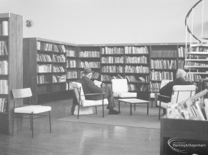 London Borough of Havering Central Library, Romford, showing bookcases and armchairs by open spiral staircase, 1967