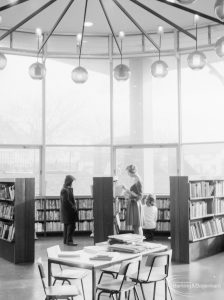 London Borough of Havering Central Library, Romford, showing junior library, with librarian at bookcase, 1967