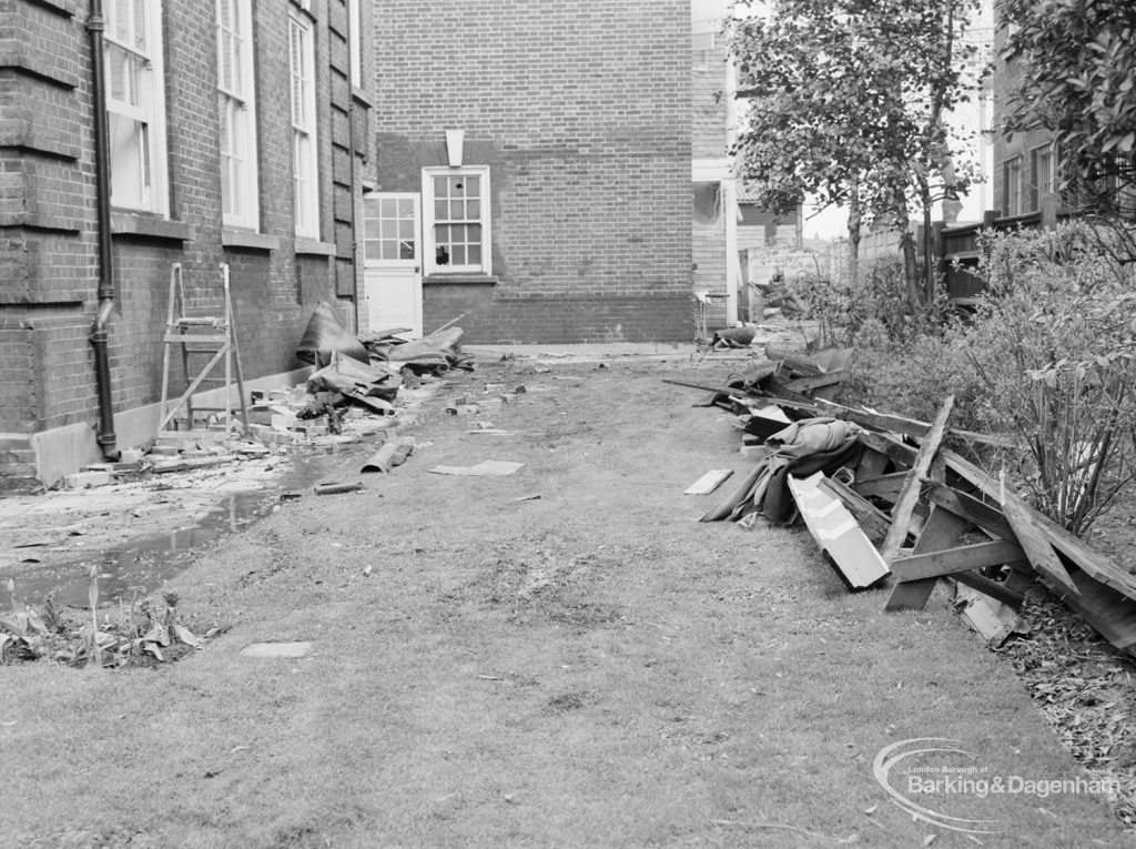 Fire at Barking Central Library, showing debris on ground below wall of original library, 1967