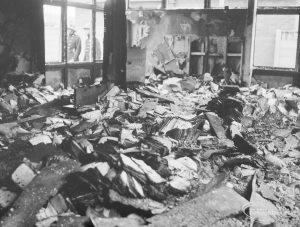 Fire at Barking Central Library, showing fused burnt books and issue cards covering floor, 1967