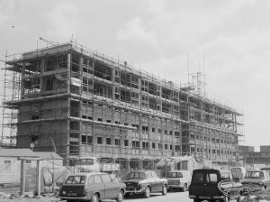 Housing development, showing new block of flats at Becontree Heath, with scaffolding and cars, 1967