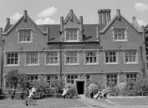 Eastbury House, Barking after restoration, showing the east exterior in strong sunshine with figures on lawn, 1967
