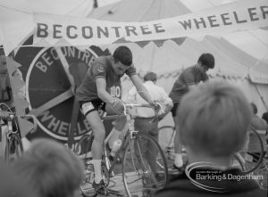 Dagenham Town Show 1967, showing the Becontree Wheelers cycling display, with two cyclists pedalling hard, 1967