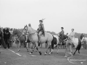 Barking Carnival 1967, showing equestrians in fancy dress riding horses past dais, 1967
