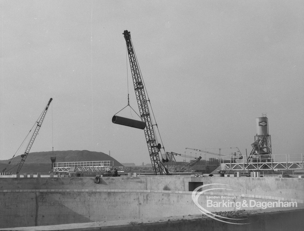 Sewage Works Reconstruction (Riverside Treatment Works) XX, showing crane lowering pipe positioned beyond tanks, 1967