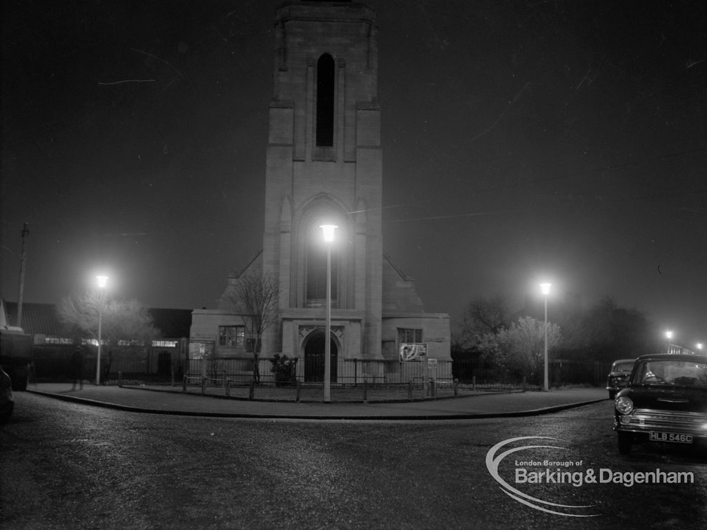 Street lighting at night in Dagenham, also showing Saint Alban’s Church tower at junction of Urswick Road and Vincent Road, 1968