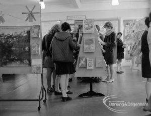 Barking Libraries Children’s Book Week [18th to 27th March] at Valence House, Dagenham, showing group of people looking at books on central stand, 1968