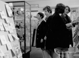 Barking Libraries Children’s Book Week [18th to 27th March] at Valence House, Dagenham, showing group of people looking at dolls in display case and books, 1968