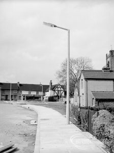 Street lighting, showing seven new lamps in Church Lane, Dagenham, witrh Cross Keys Public House and St Peter and St Paul’s Parish Church behind, 1968