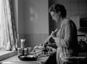 Child Welfare, showing warden Mrs Chapman preparing sausages [possibly in house at 100 Balgores Lane, Gidea Park], 1968
