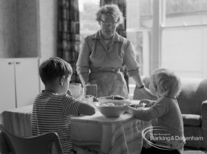 Child Welfare at Woodstock Hall House, Harold Wood, showing woman with two children at meal, 1968