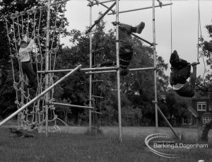 Child Welfare at Woodstock Hall House, Harold Wood, showing children on climbing apparatus, with two boys hanging upside down, 1968