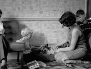 Child Welfare at Woodstock Hall House, Harold Wood, showing girl kneeling and stroking dog, with boys watching, 1968